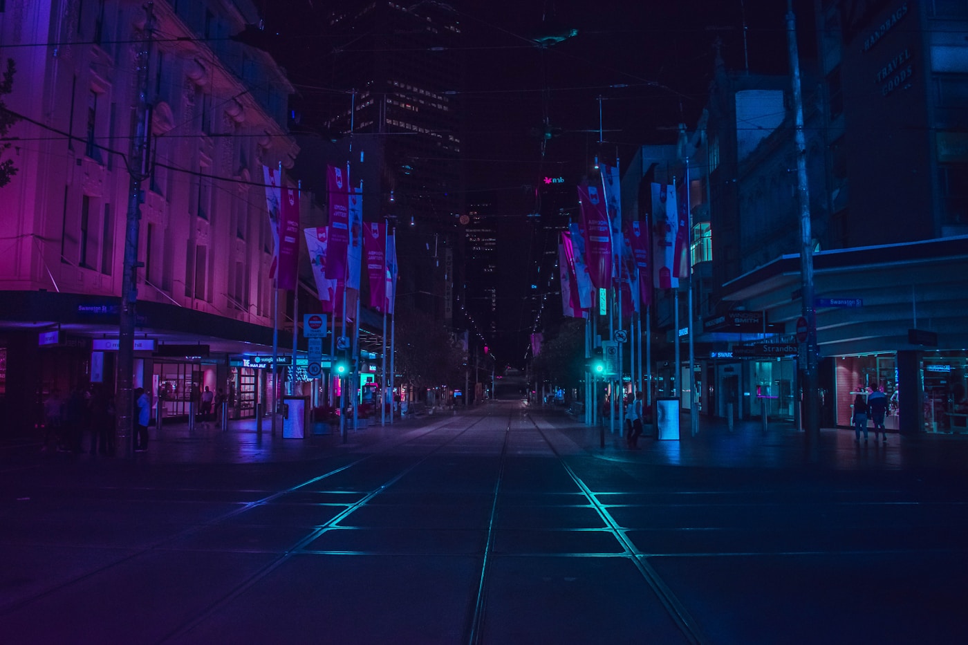 A city street glowing with purple and blue lights at night